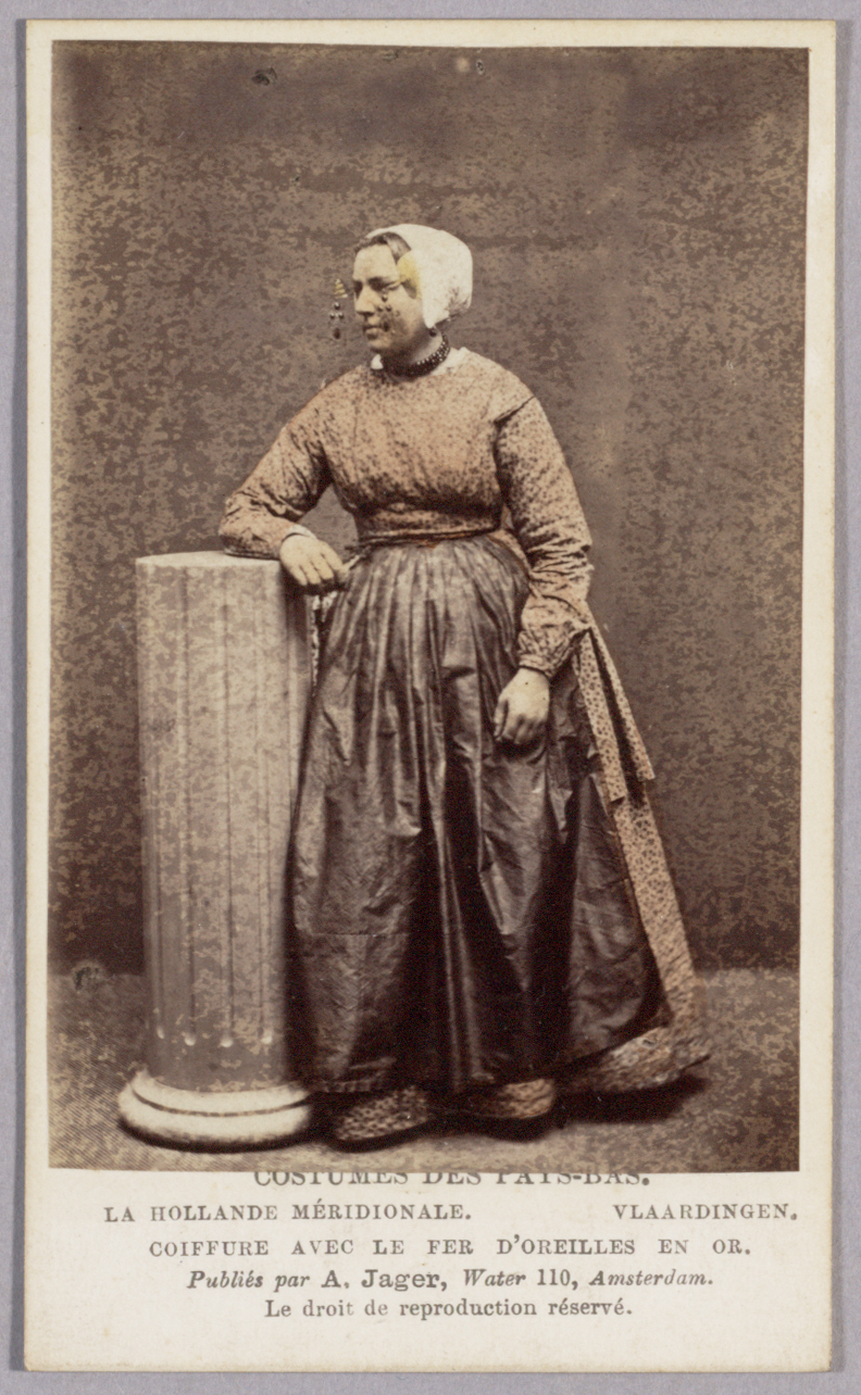 Vrouw in klederdracht van Vlaardingen met gouden oorijzer (Zuid-Nederland).